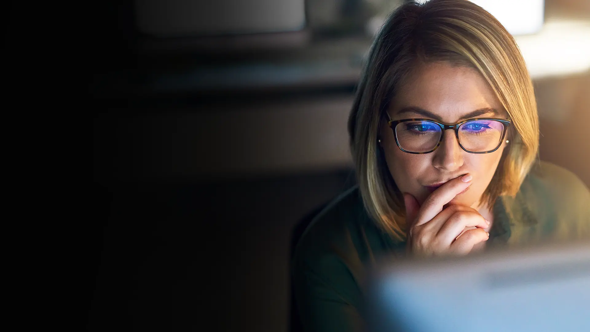 Professional woman looking at a screen, remotely mentoring a refugee