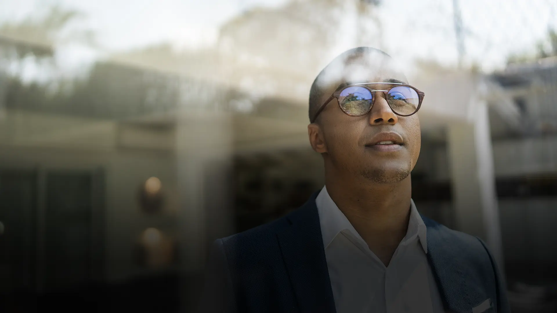 Happy business man looks into the distance through window.