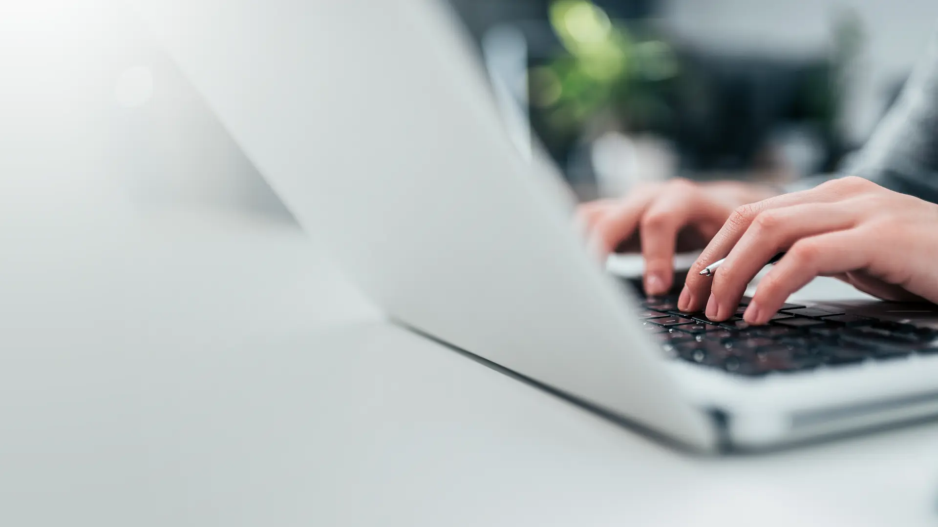 Hands of a woman typing at a keyboard, taking a BecomingX corporate learning course