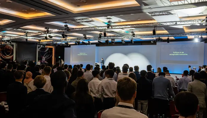 View of the stage of a BecomingX corporate training session for hundreds of people in a large hall