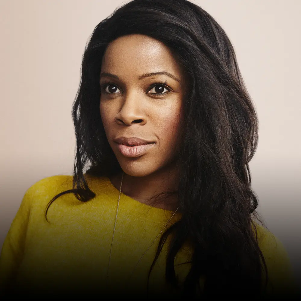 Portrait of a black female Accenture Managing Director wearing a yellow jumper.