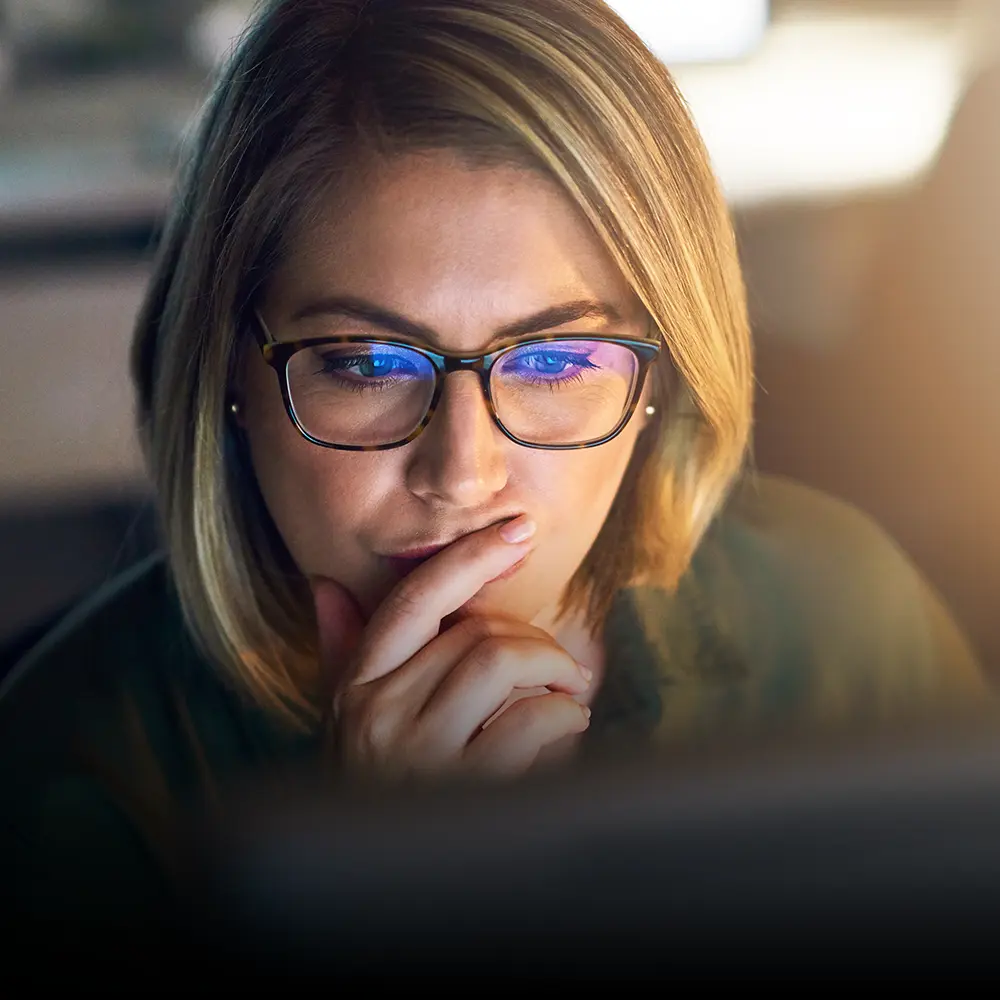 Professional woman looking at a screen, remotely mentoring a refugee